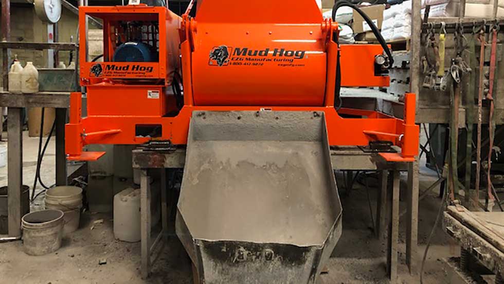 An industrial cement mixer pours out castable refractory cement for manufacturing custom refractory shapes.